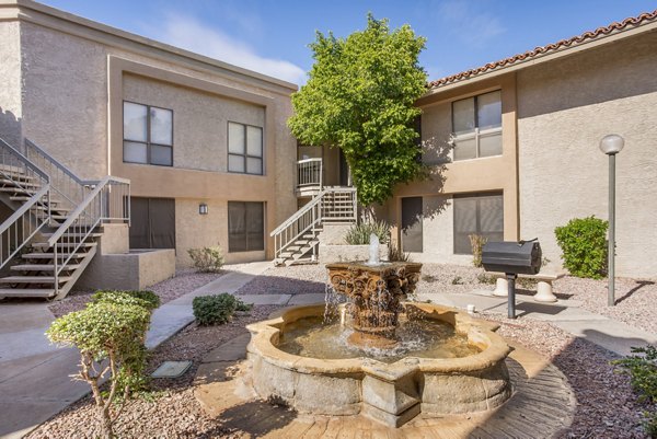 Outdoor grill area with seating and greenery at Avana at the Pointe Apartments, perfect for social gatherings and cookouts
