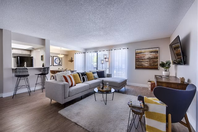 Spacious living room with modern decor and large windows in Avana at the Pointe Apartments