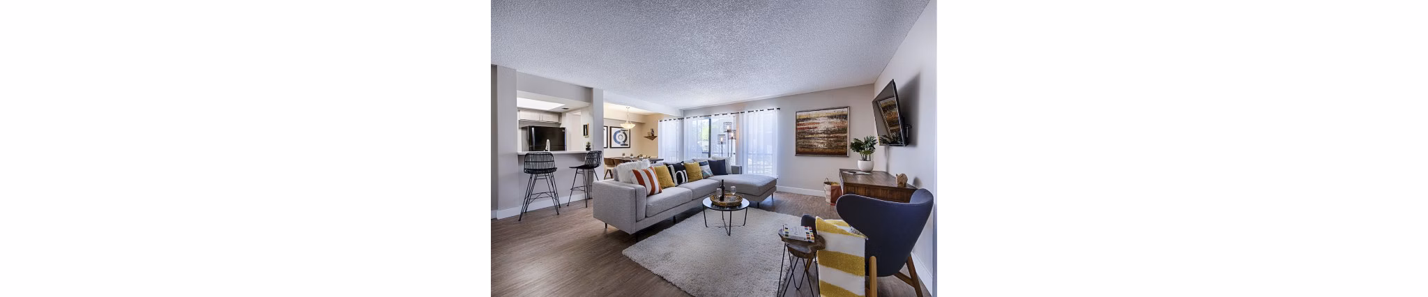 Spacious living room with modern decor and large windows in Avana at the Pointe Apartments