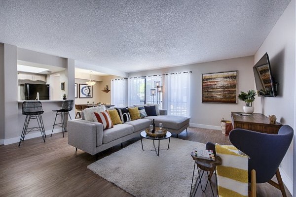 Spacious living room with modern decor and large windows in Avana at the Pointe Apartments