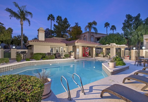 Resort-style pool surrounded by lush landscaping at Avana at the Pointe Apartments