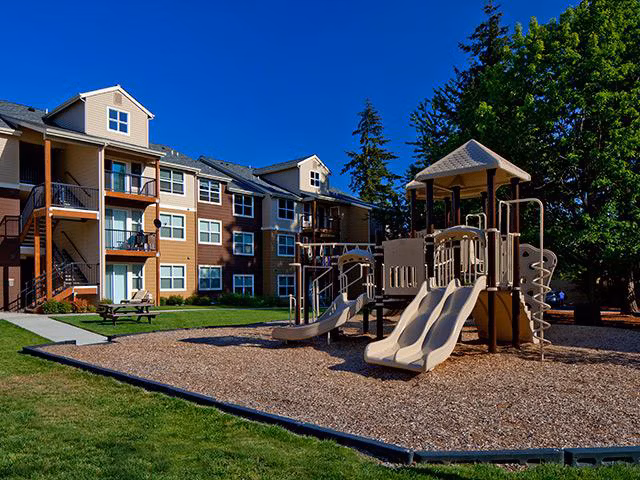 Colorful playground with modern equipment at Jory Trail Apartments, providing family-friendly outdoor fun for residents