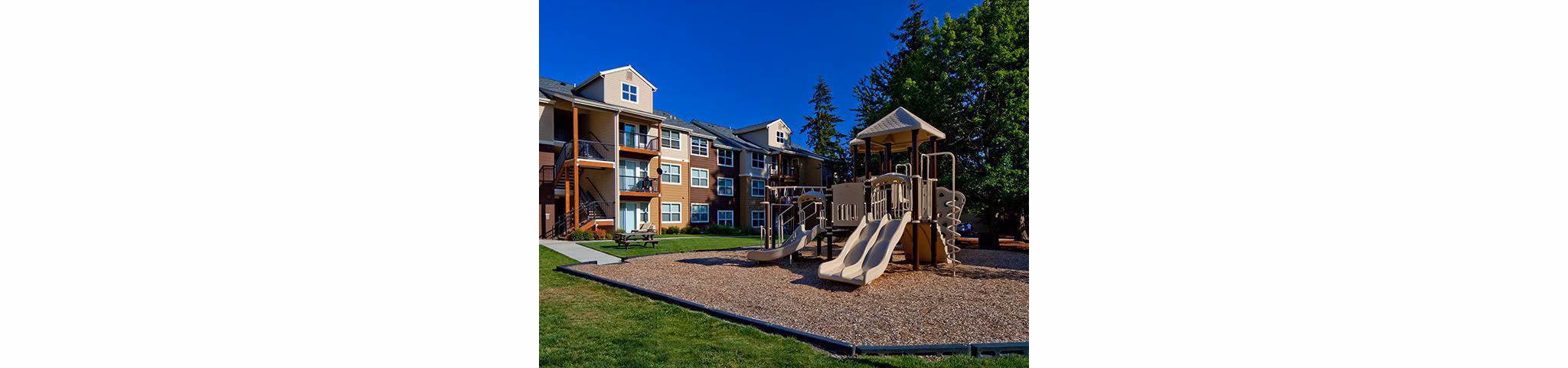 Colorful playground with modern equipment at Jory Trail Apartments, providing family-friendly outdoor fun for residents