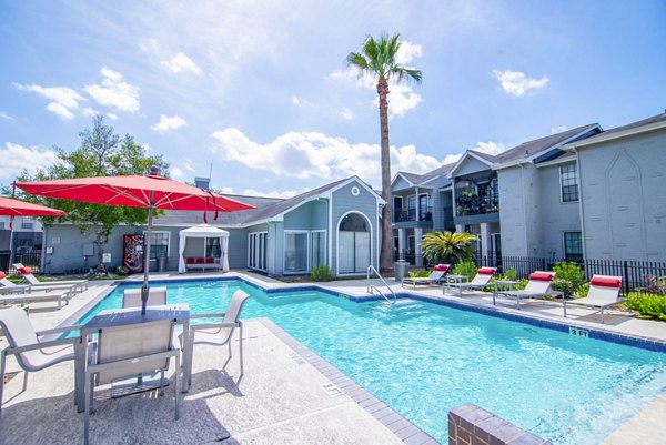 Inviting outdoor pool at Green Tree Place Apartments with lush landscaping and modern seating