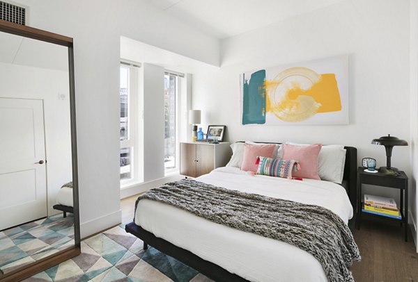 Spacious bedroom with modern decor at The Ludlow Apartments in downtown area, offering luxury living with ample natural light