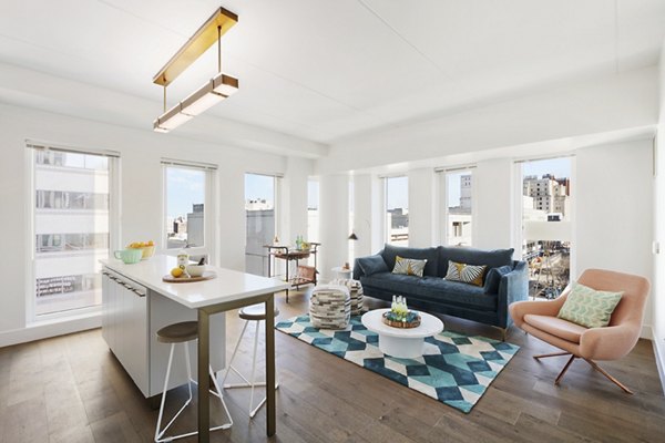 Living room with modern dÃ©cor and large windows at The Ludlow Apartments, luxury living in New York City