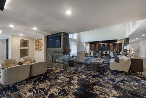 Modern lounge area with seating, fireplace, and TV in luxury apartments