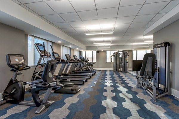 Modern fitness center with treadmills, stationary bikes, and weight machines in luxury apartments