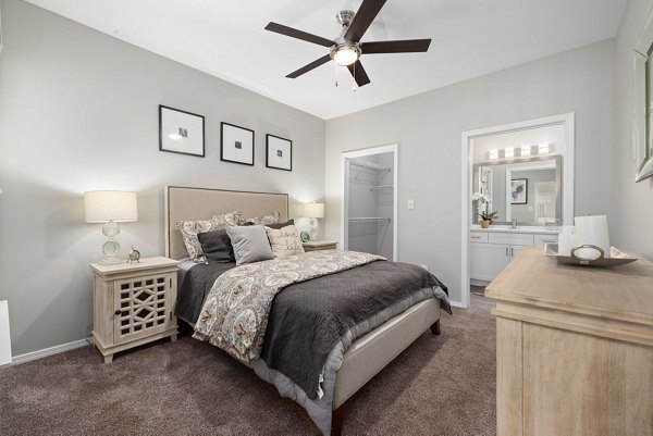 Cozy bedroom with modern decor at Cary Greens at Preston Apartments, offering luxury living in a serene environment