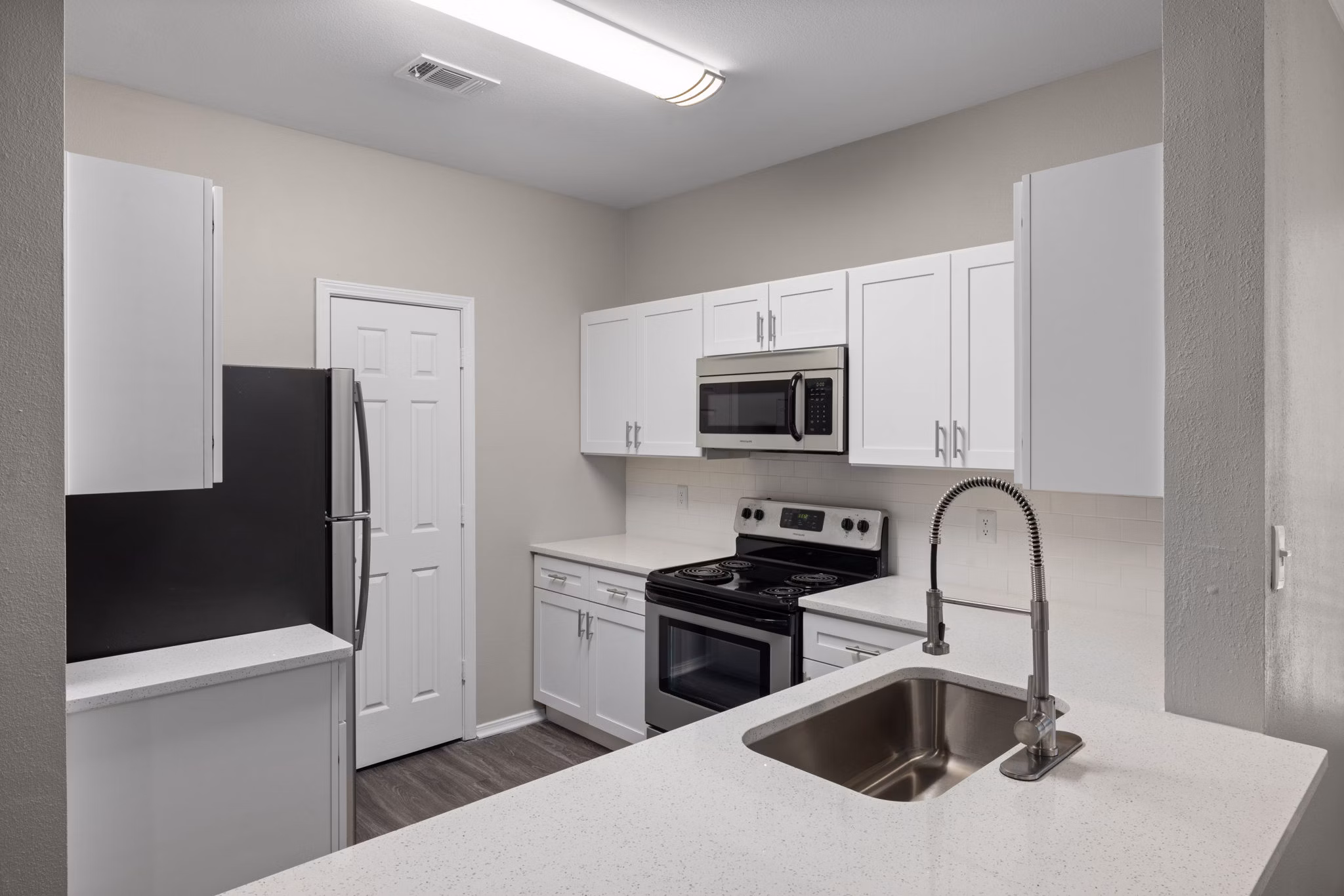 Modern kitchen with sleek appliances and granite countertops at Cary Greens at Preston Apartments