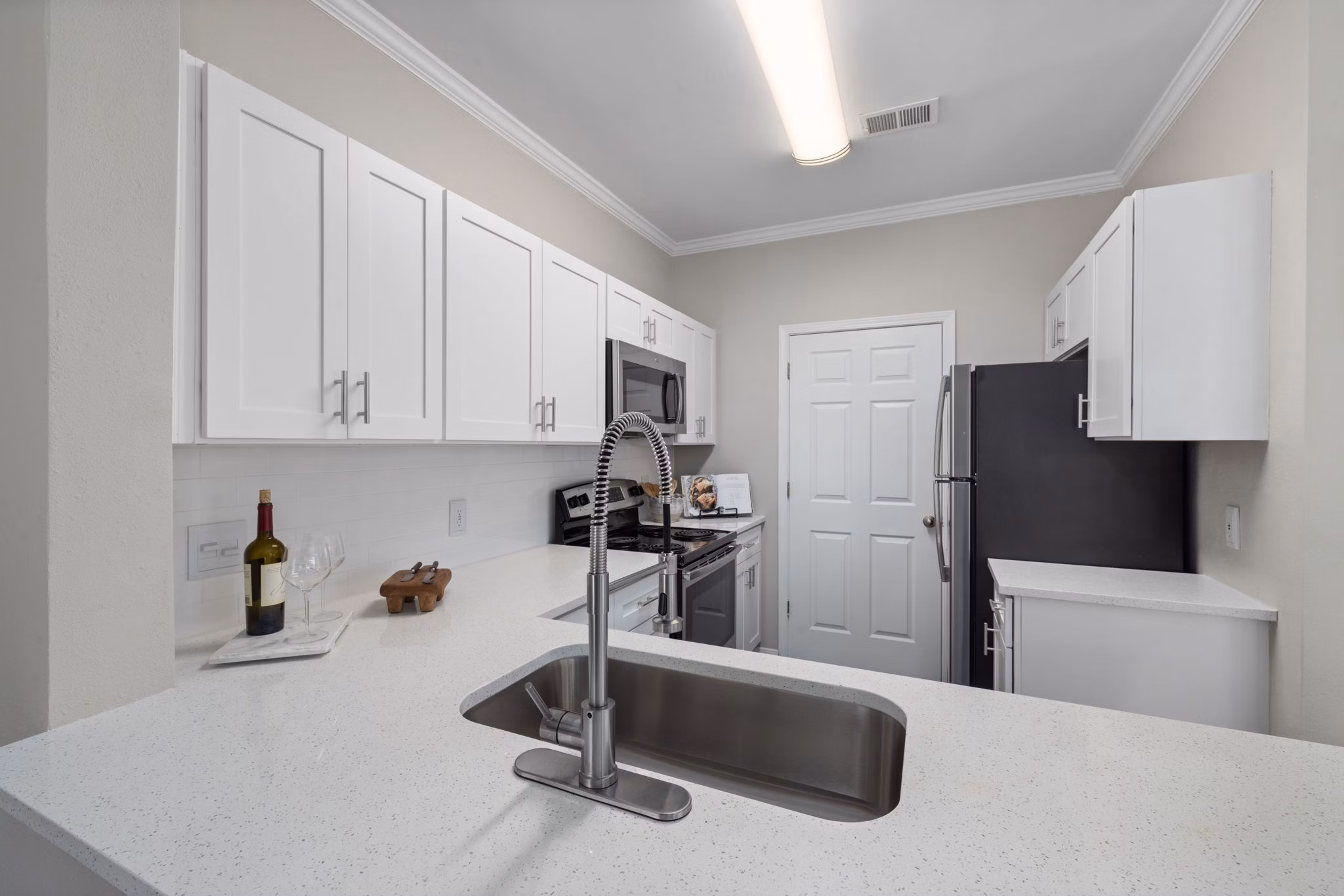 Modern kitchen with stainless steel appliances and granite countertops in Cary Greens at Preston Apartments