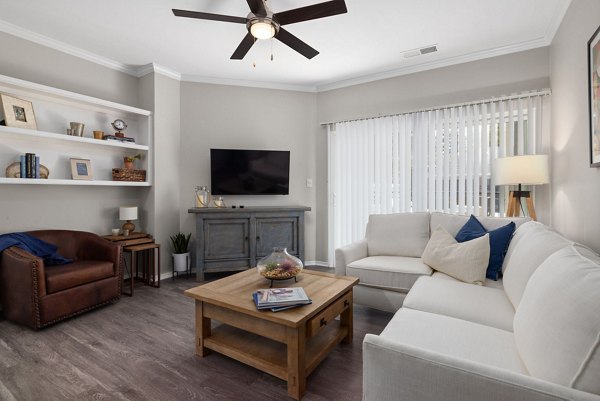 Spacious living room with contemporary decor in Cary Greens at Preston Apartments, highlighting elegance and comfort for modern luxury living