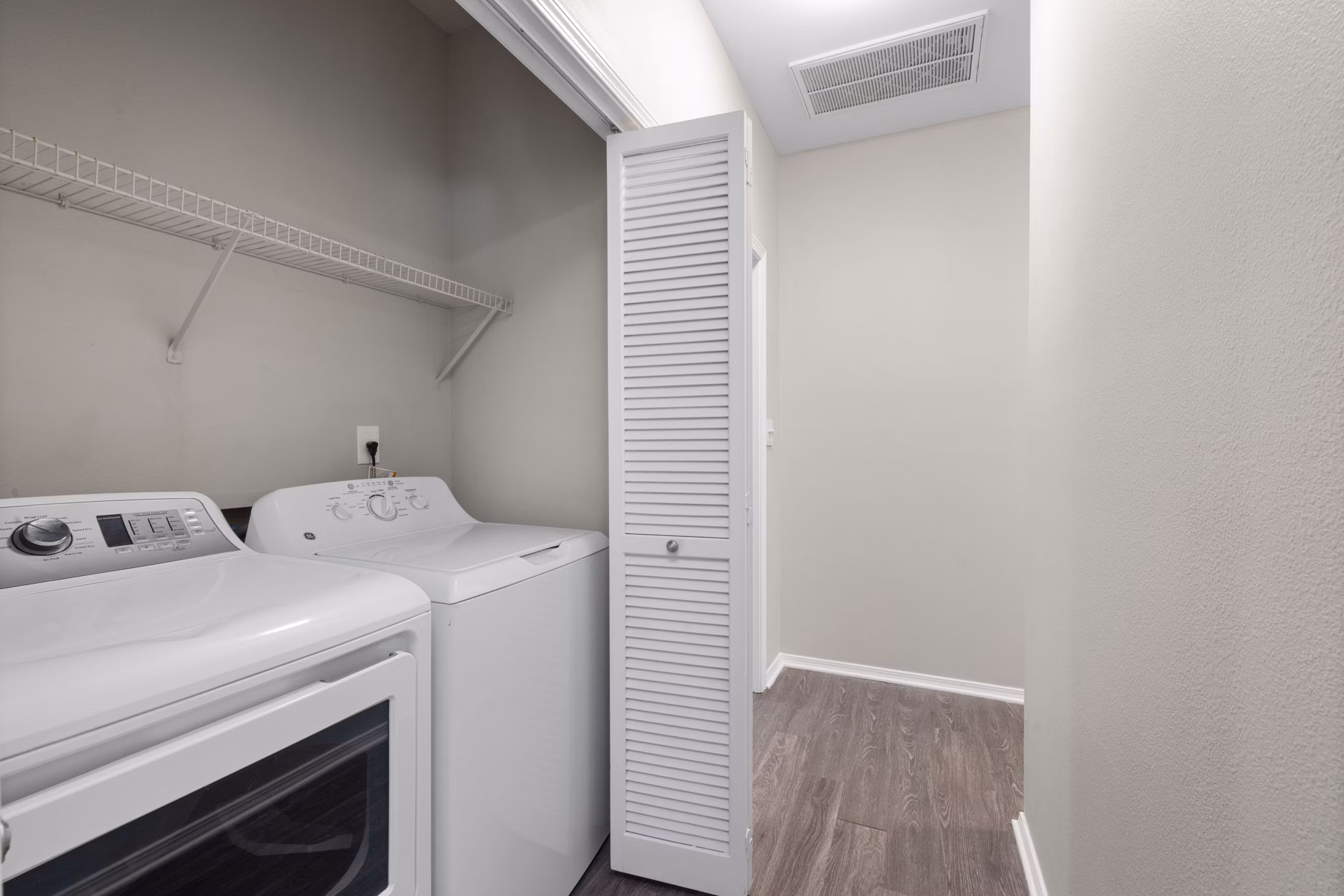 Laundry room featuring modern appliances at Cary Greens at Preston Apartments