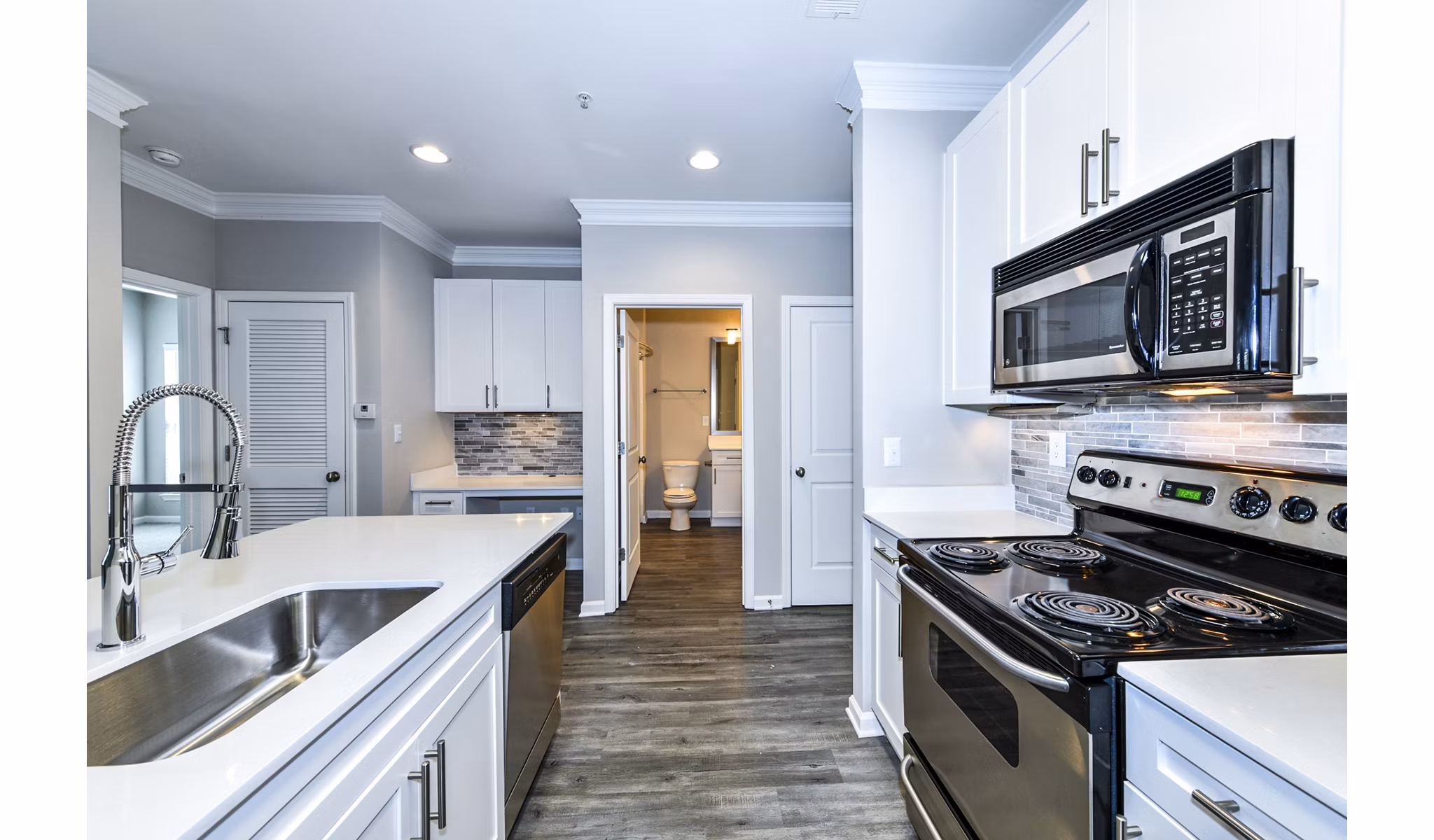 Kitchen featuring modern appliances and granite countertops in Avana City North Apartments