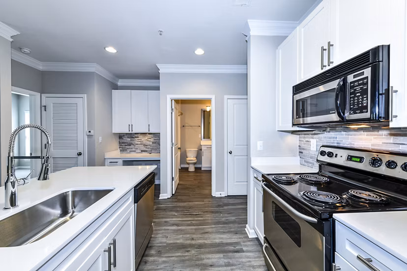 Kitchen featuring modern appliances and granite countertops in Avana City North Apartments
