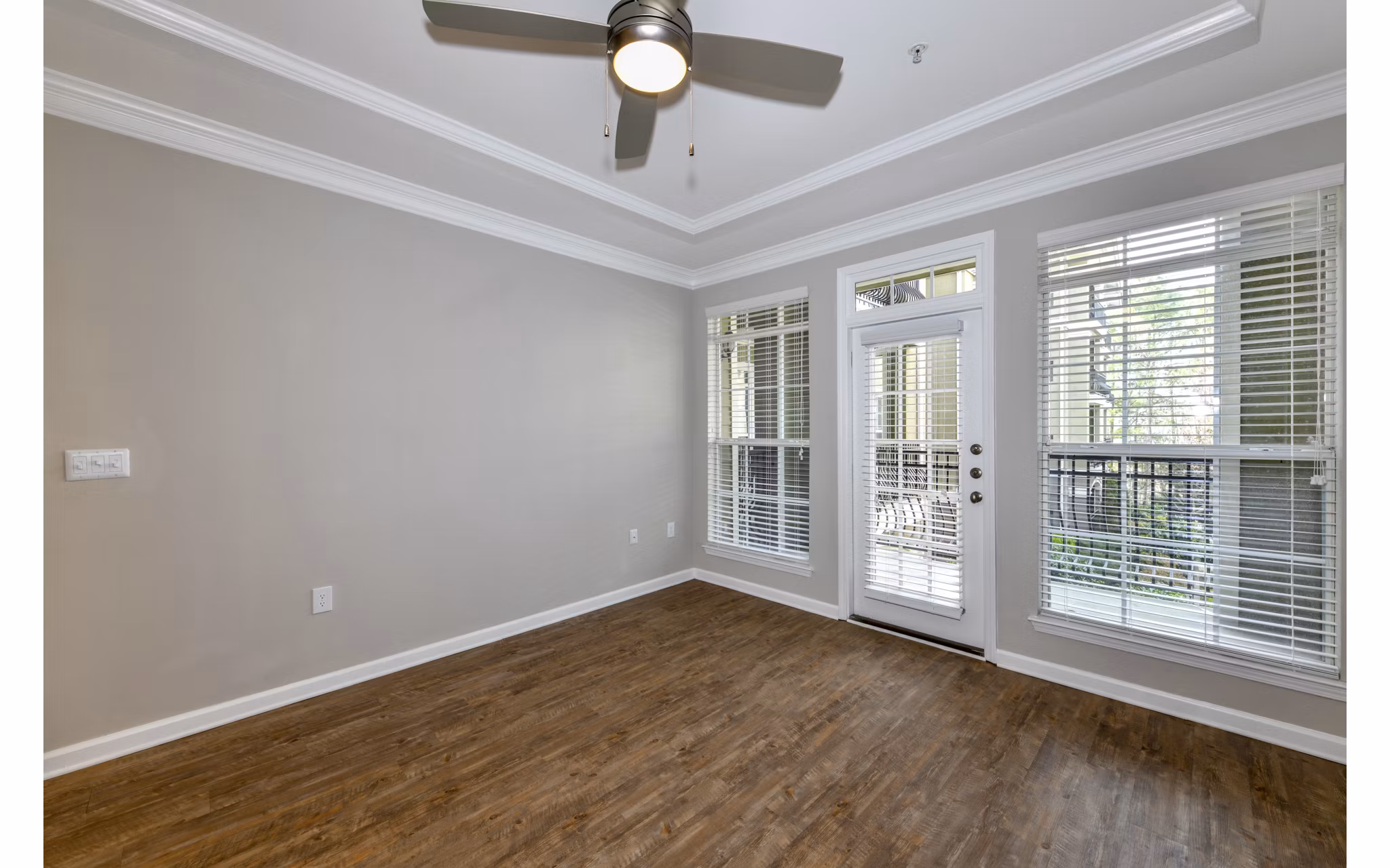 Spacious living room with modern decor and large windows in Avana City North Apartments