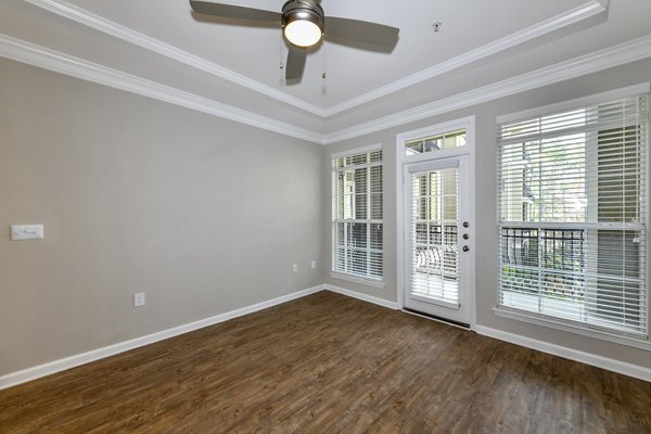 Spacious living room with modern decor and large windows in Avana City North Apartments