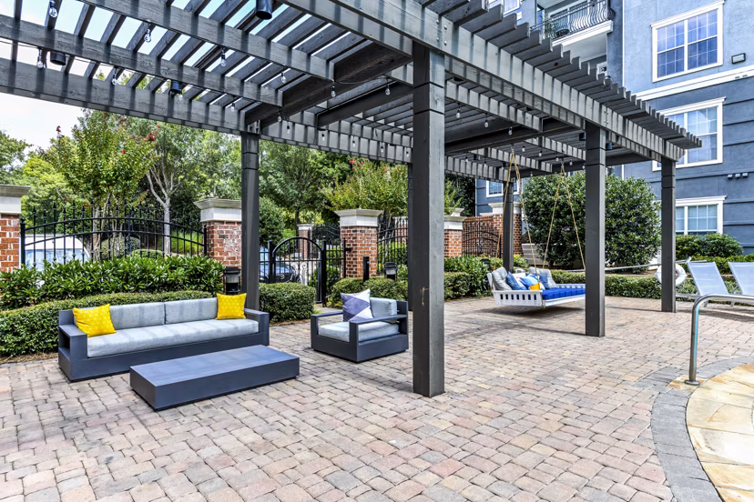 Poolside relaxation area with stylish patio furniture at Avana City North Apartments