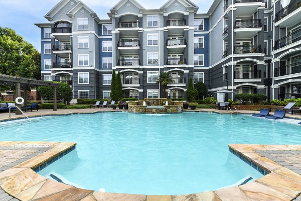 Relaxing outdoor pool surrounded by lush landscaping at Avana City North Apartments