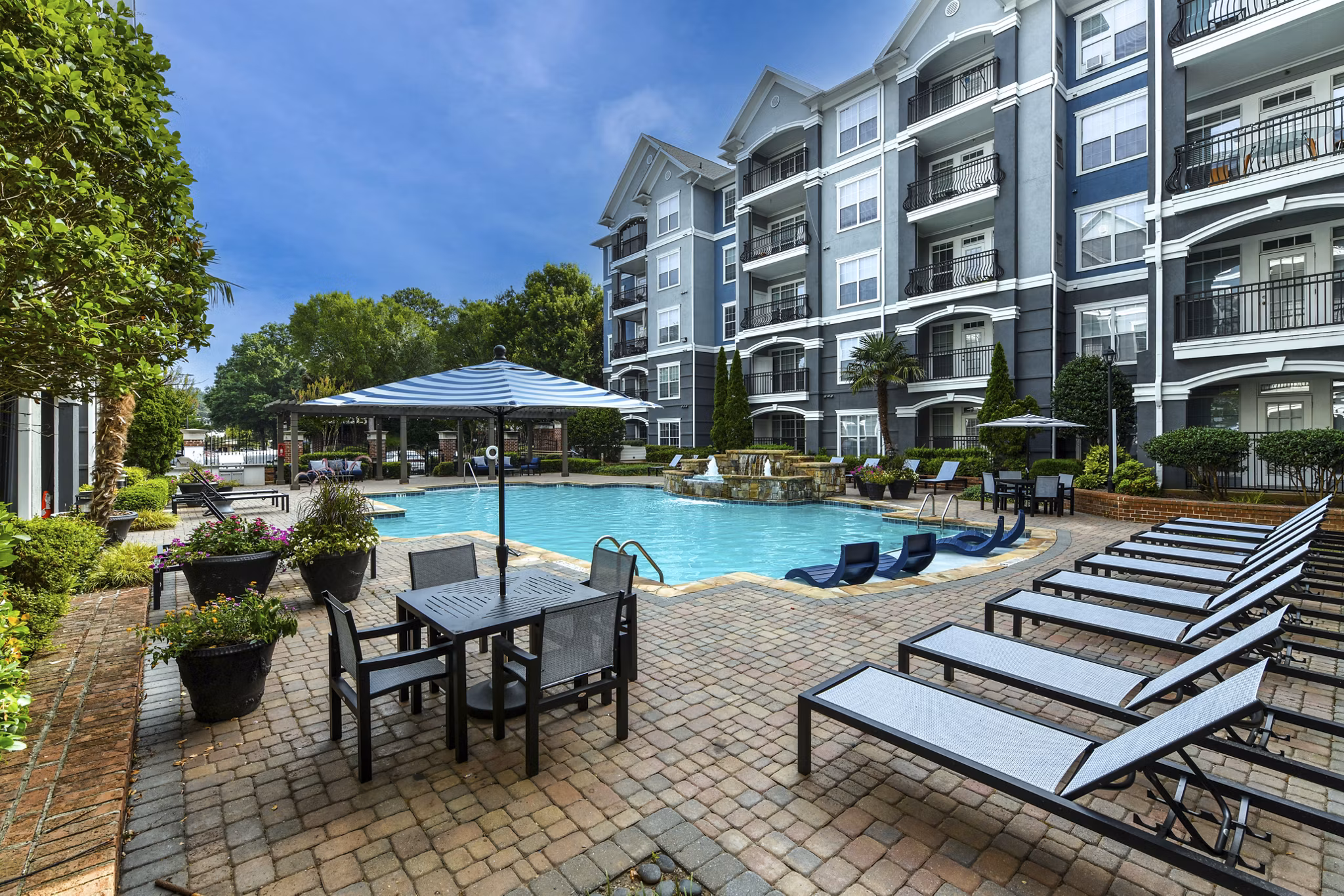 Outdoor pool with lounge chairs at Avana City North Apartments for leisure and relaxation