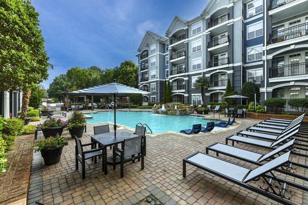 Outdoor pool with lounge chairs at Avana City North Apartments for leisure and relaxation