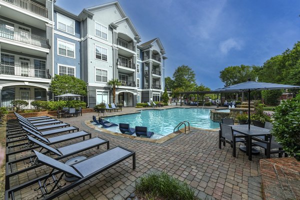 Relaxing outdoor pool at Avana City North Apartments with loungers and greenery