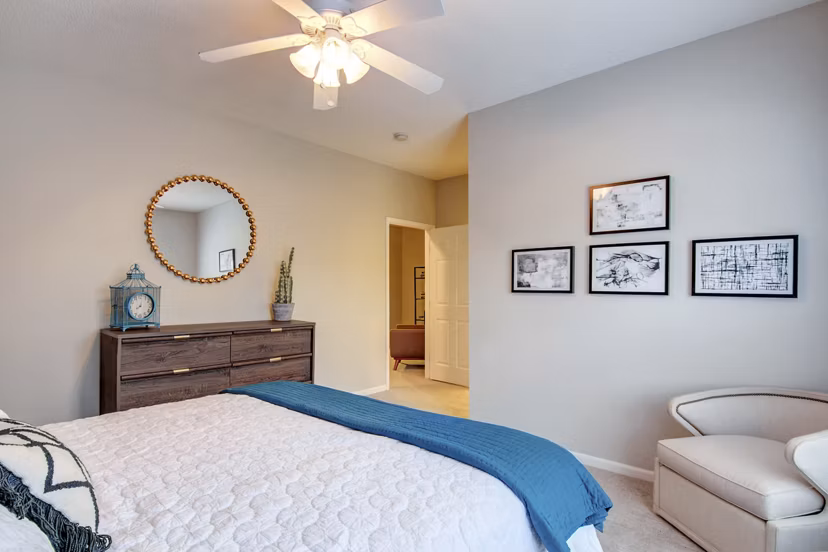 Bedroom with elegant decor and large windows at The Grand Reserve Apartments