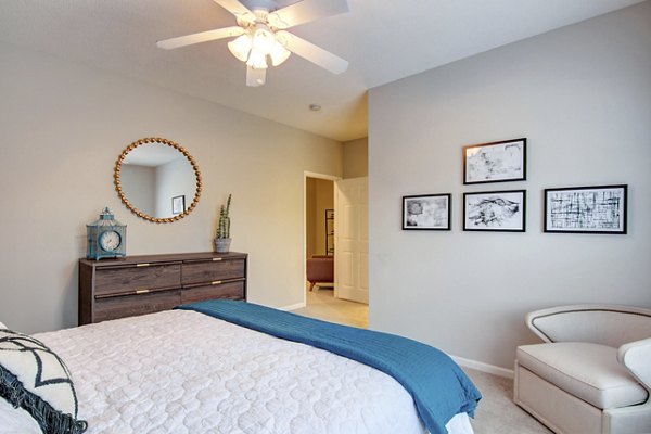 Bedroom with elegant decor and large windows at The Grand Reserve Apartments