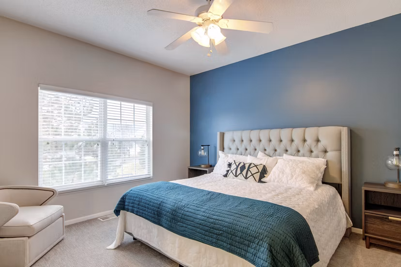 Bedroom with elegant decor and natural light at The Grand Reserve Apartments
