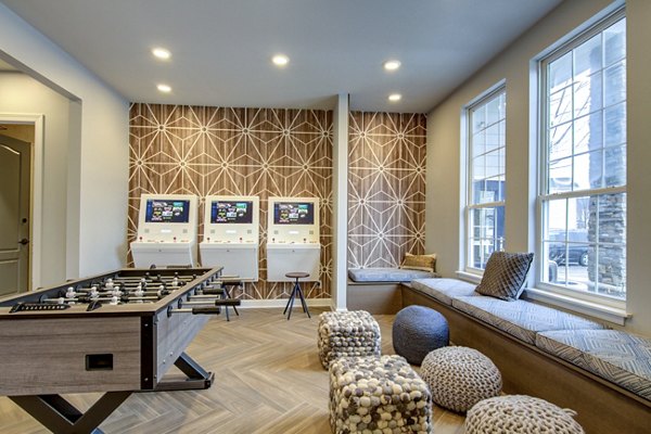 Game room with pool table and lounge seating at The Grand Reserve Apartments featuring luxury amenities for relaxation and entertainment