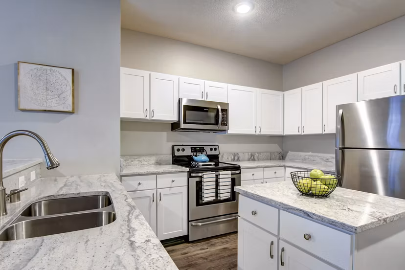Kitchens featuring modern appliances and granite countertops at The Grand Reserve Apartments