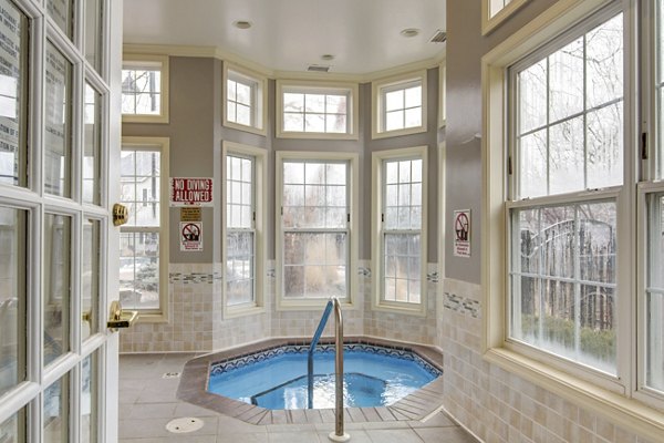Relaxing hot tub at The Grand Reserve Apartments in a lush garden setting
