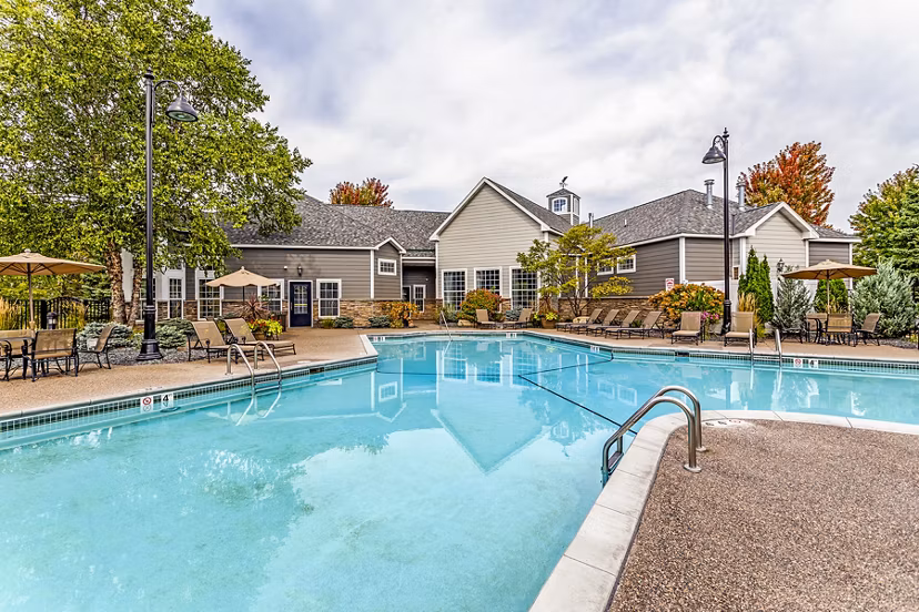 Luxury outdoor pool with sun loungers at The Grand Reserve Apartments