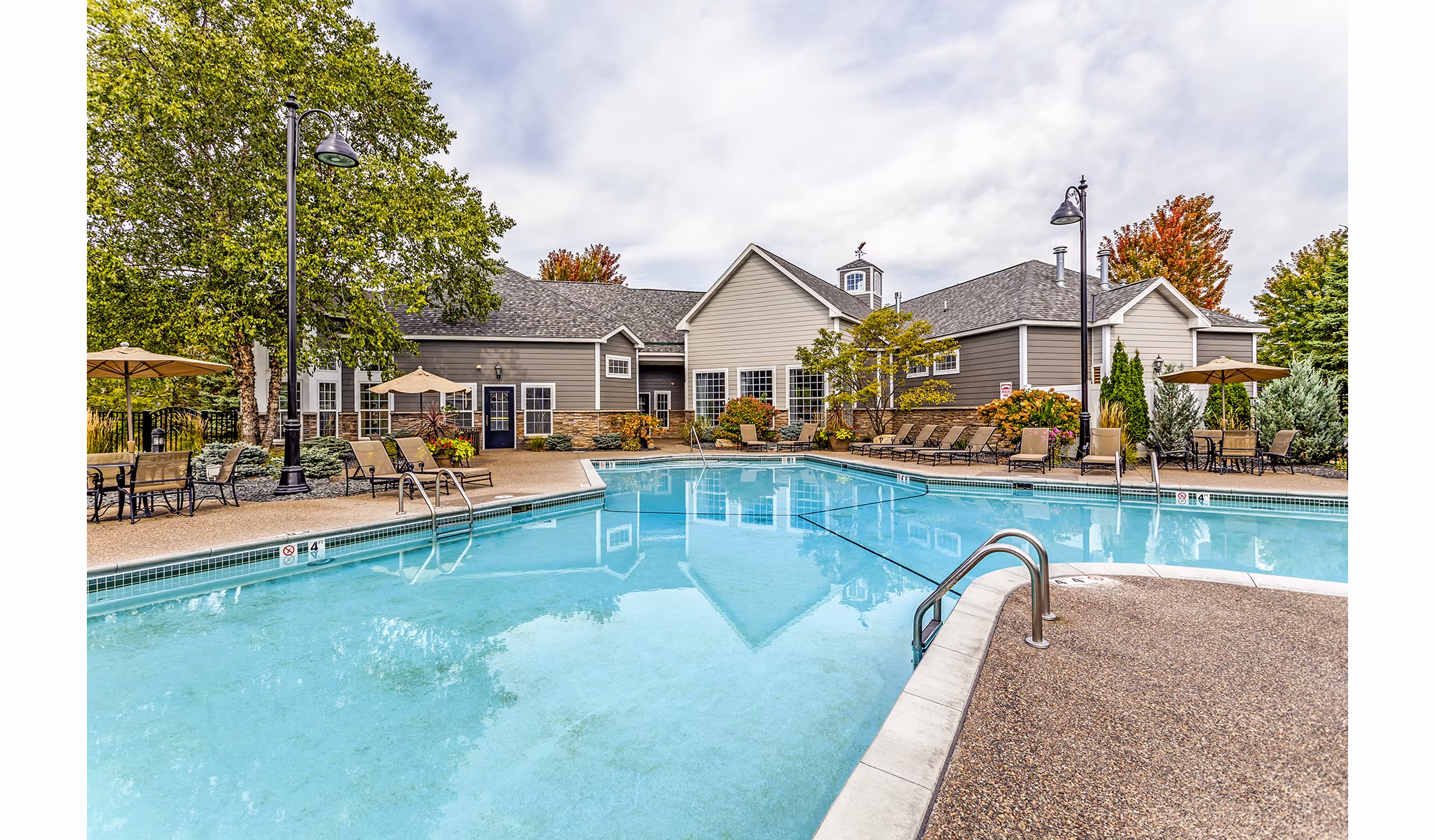 Luxury outdoor pool with sun loungers at The Grand Reserve Apartments