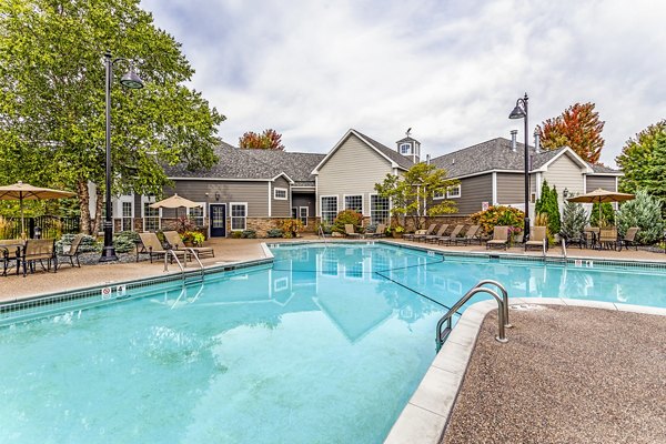 Luxury outdoor pool with sun loungers at The Grand Reserve Apartments