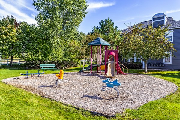 Colorful community playground at The Grand Reserve Apartments featuring swings and slides