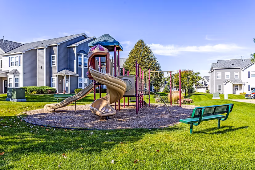 Playground featuring colorful play structures at The Grand Reserve Apartments, perfect for family fun and outdoor activities