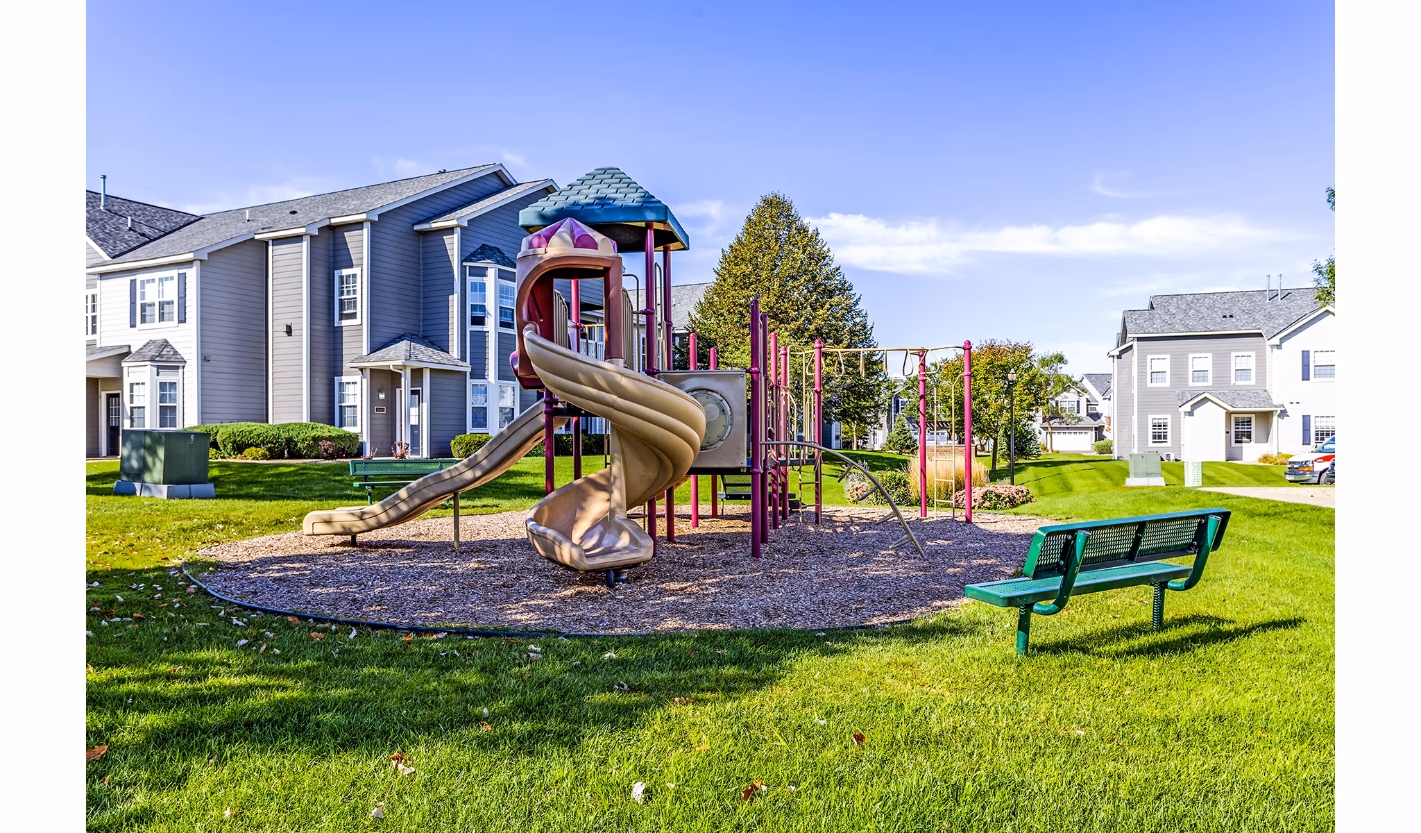 Playground featuring colorful play structures at The Grand Reserve Apartments, perfect for family fun and outdoor activities