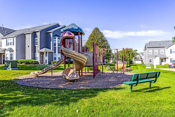 Playground featuring colorful play structures at The Grand Reserve Apartments, perfect for family fun and outdoor activities