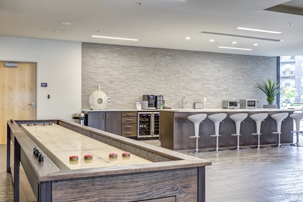 Modern clubhouse with lounge seating and pool table at Sunnen Station Apartments, offering luxury living and community events