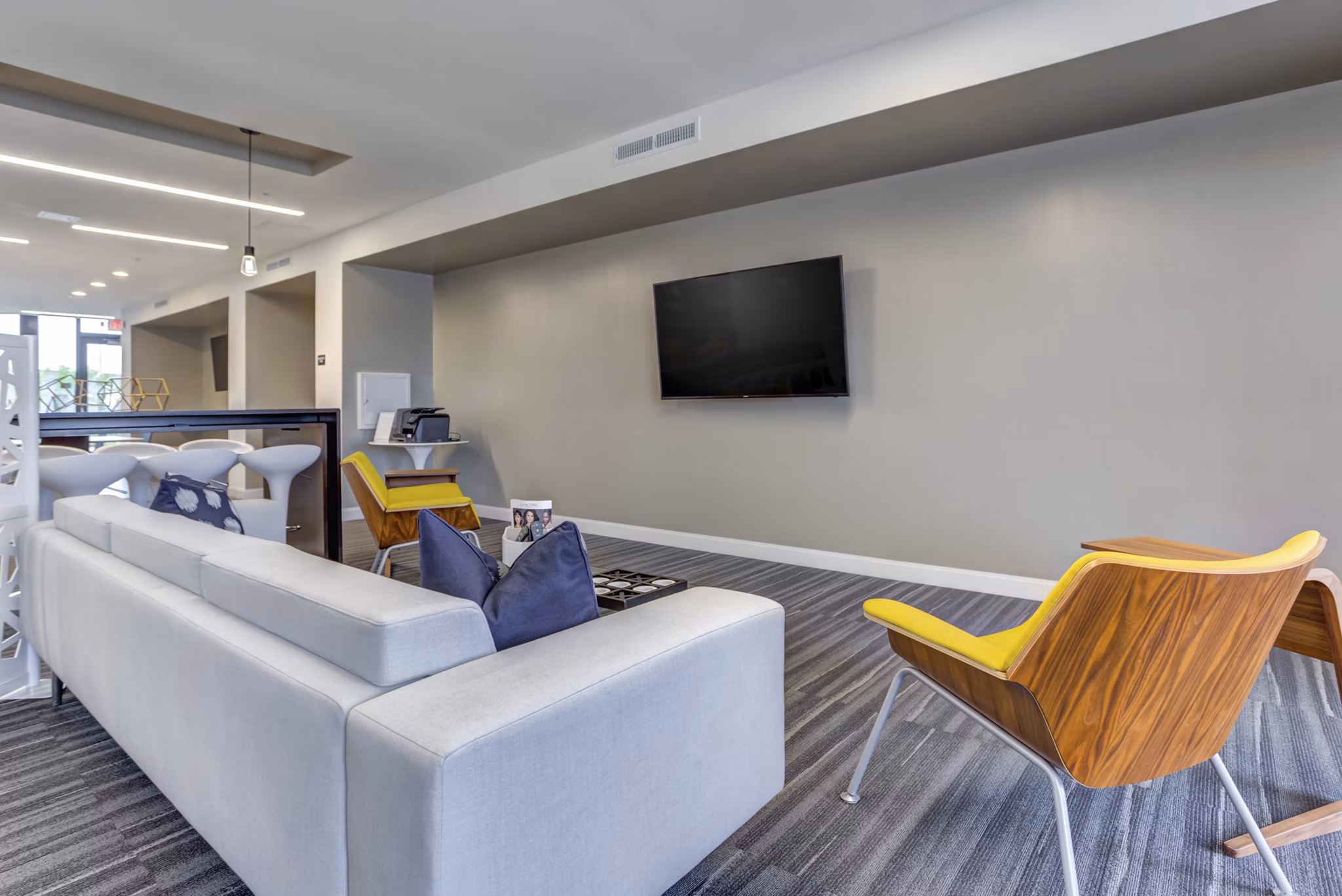 Modern clubhouse with open seating and game area at Sunnen Station Apartments