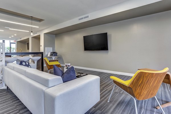 Modern clubhouse with open seating and game area at Sunnen Station Apartments
