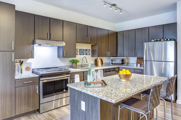 Modern kitchen featuring stainless steel appliances at Sunnen Station Apartments