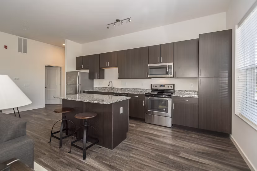 Modern kitchen with stainless steel appliances at Sunnen Station Apartments in luxury Greystar community