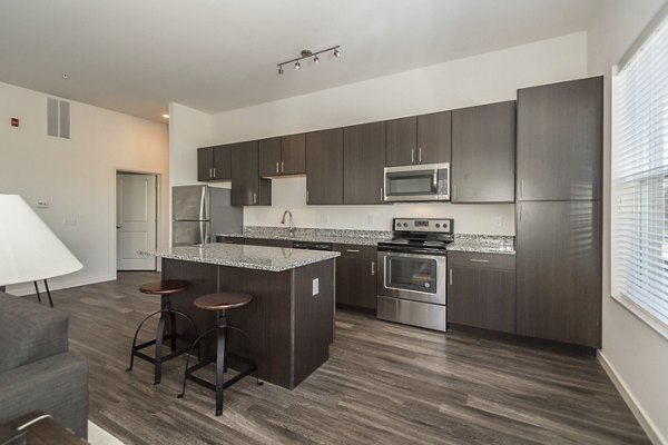 Modern kitchen with stainless steel appliances at Sunnen Station Apartments in luxury Greystar community