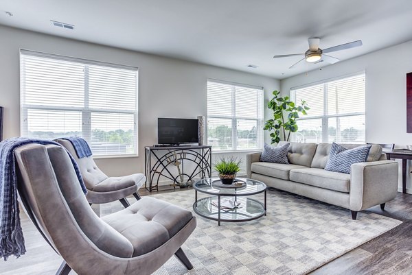 Cozy living room with modern furnishings at Sunnen Station Apartments, perfect for comfort and style in a premium residential setting