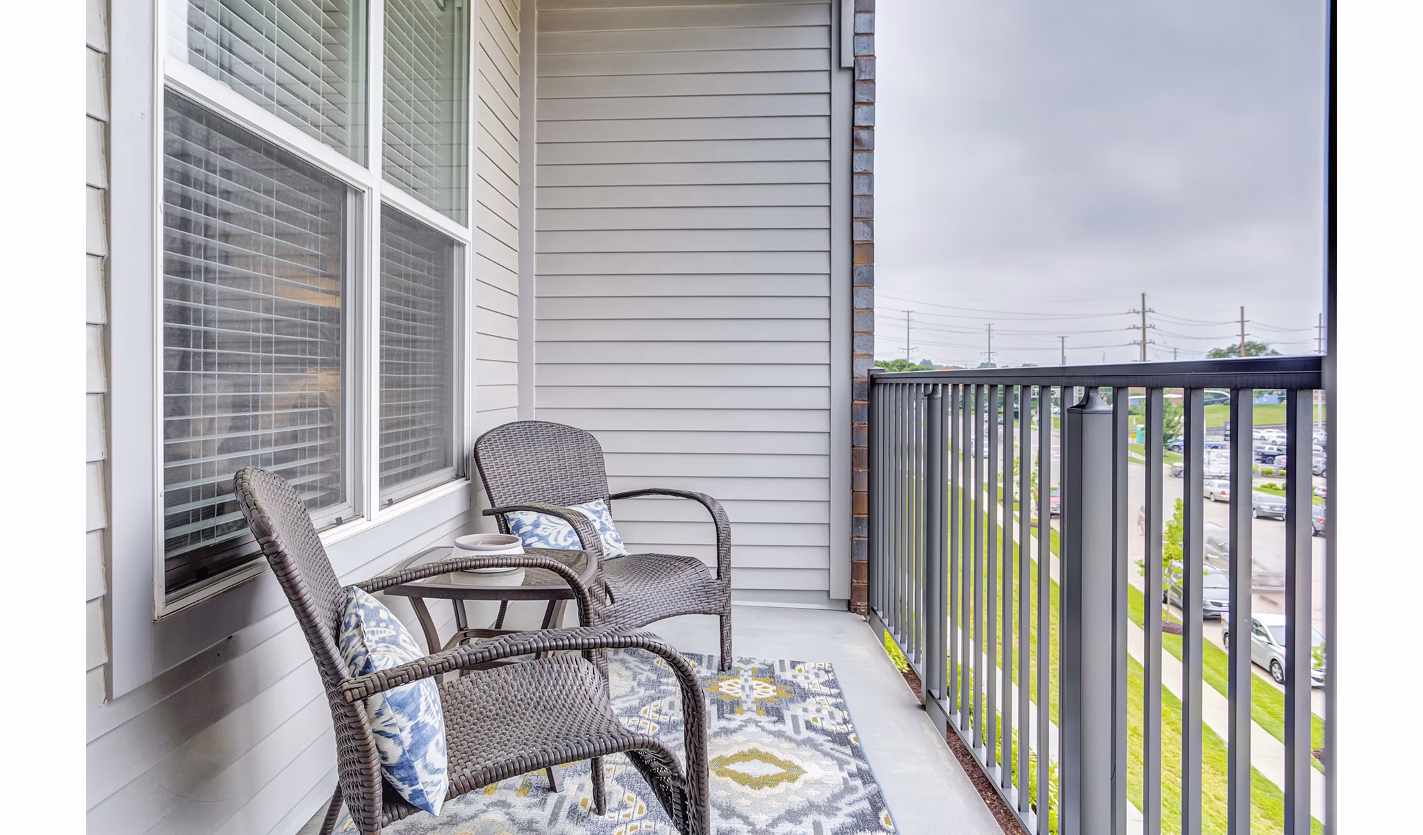Sunnen Station Apartments: Cozy patio balcony with scenic views inviting relaxation and outdoor dining