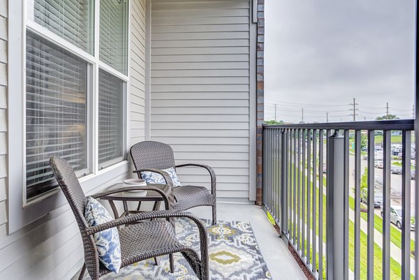 Sunnen Station Apartments: Cozy patio balcony with scenic views inviting relaxation and outdoor dining