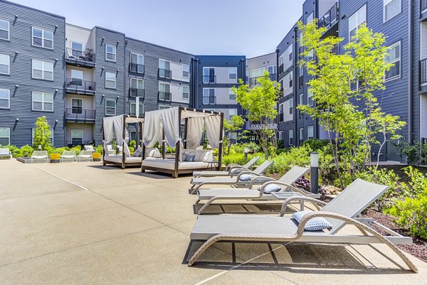 Serene outdoor pool with palm trees at The Arnold Apartments, a luxury property offering relaxing amenities in a resort-style setting