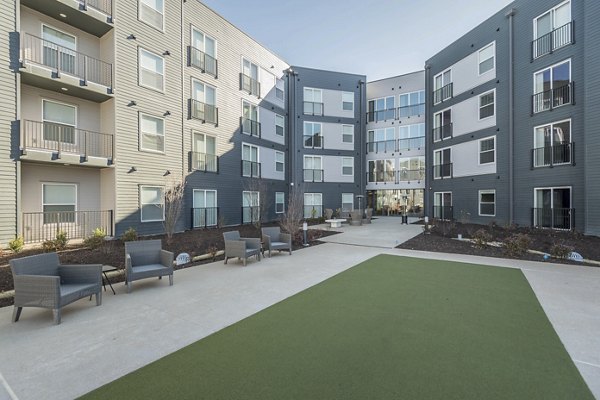 Tranquil courtyard with lush greenery at Sunnen Station Apartments, offering a serene escape within a luxury living environment